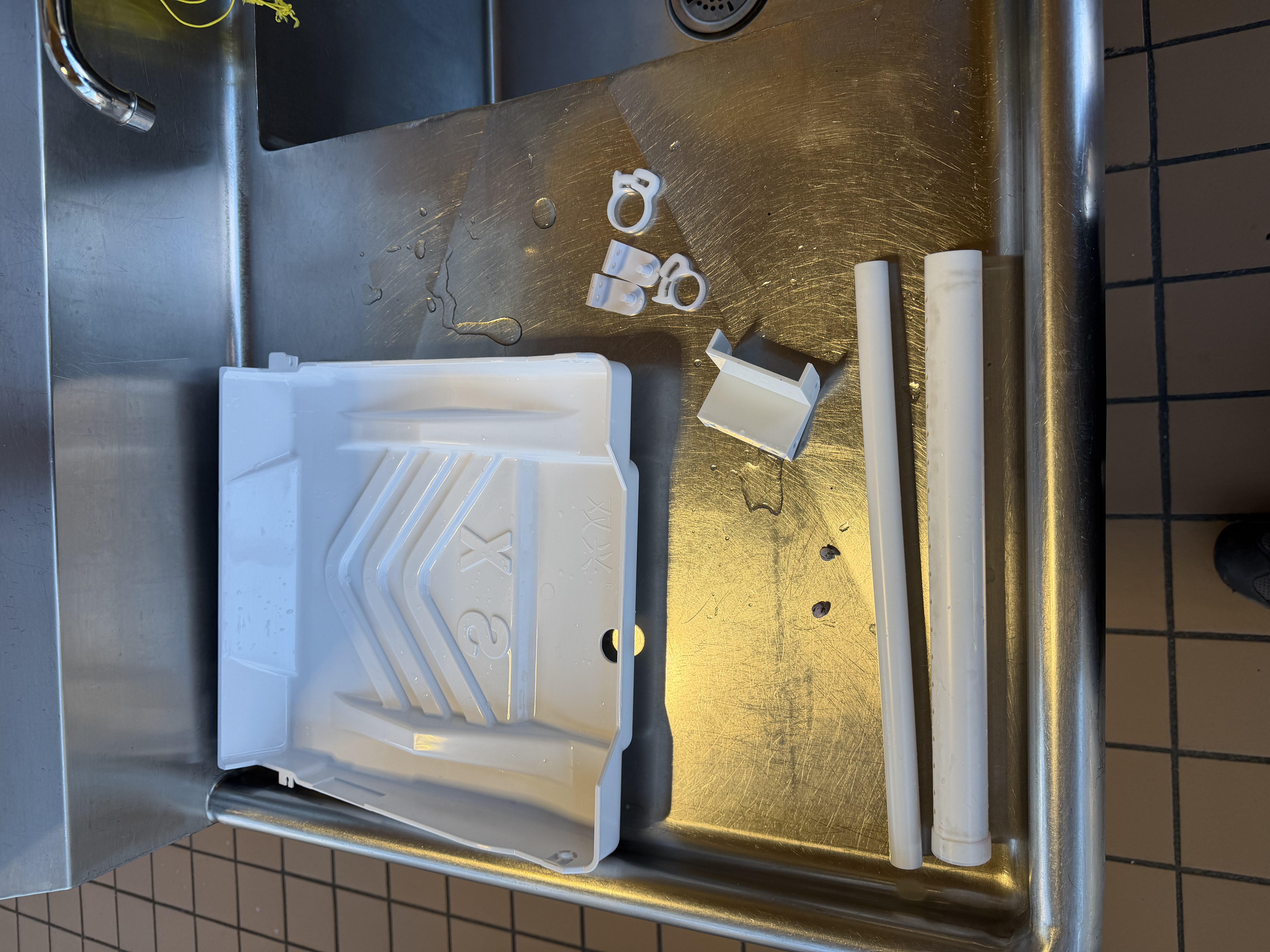 Clean ice machine tray and water pipes after maintenance