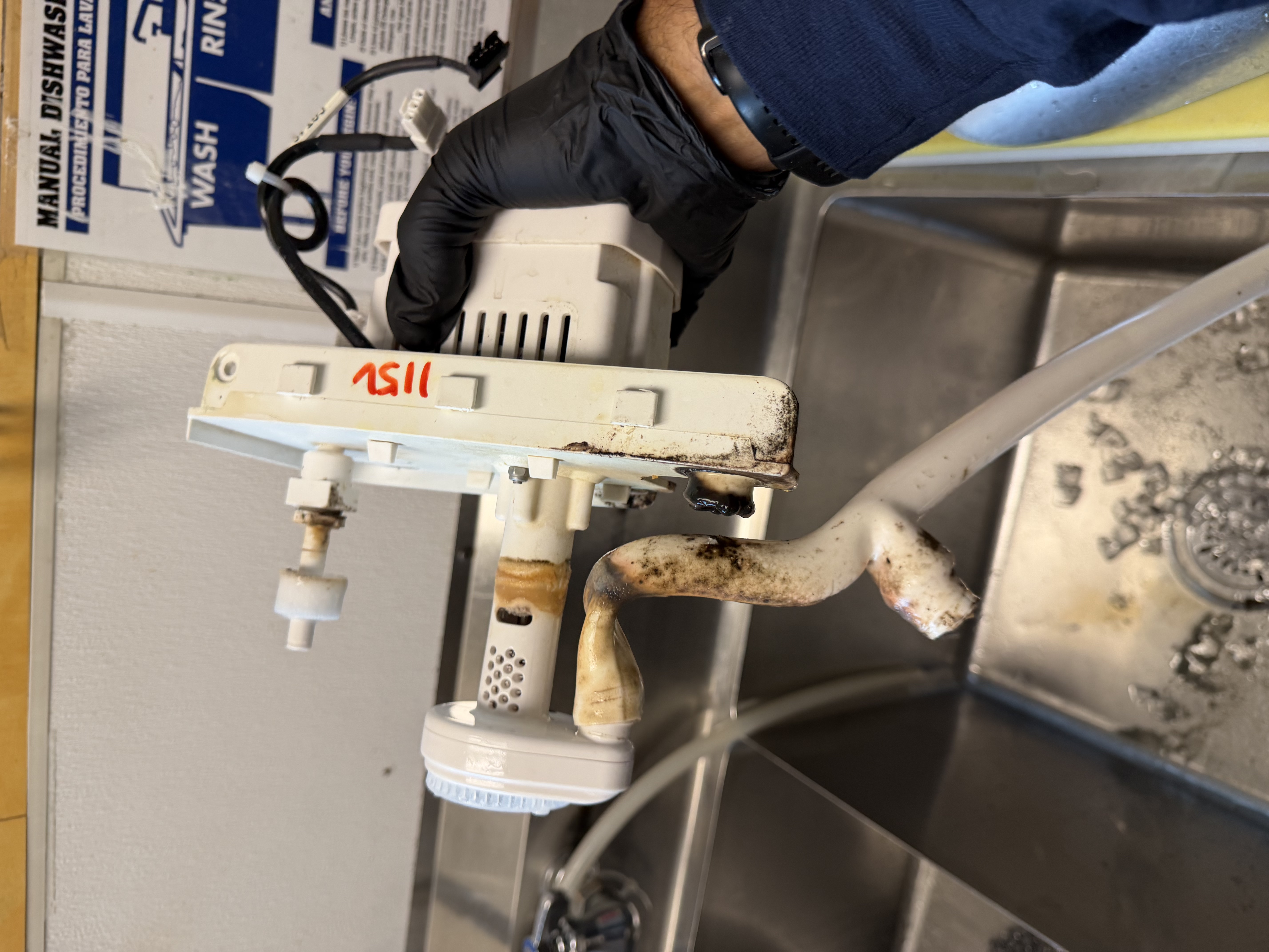 Dirty water pump removed from a commercial ice machine during maintenance