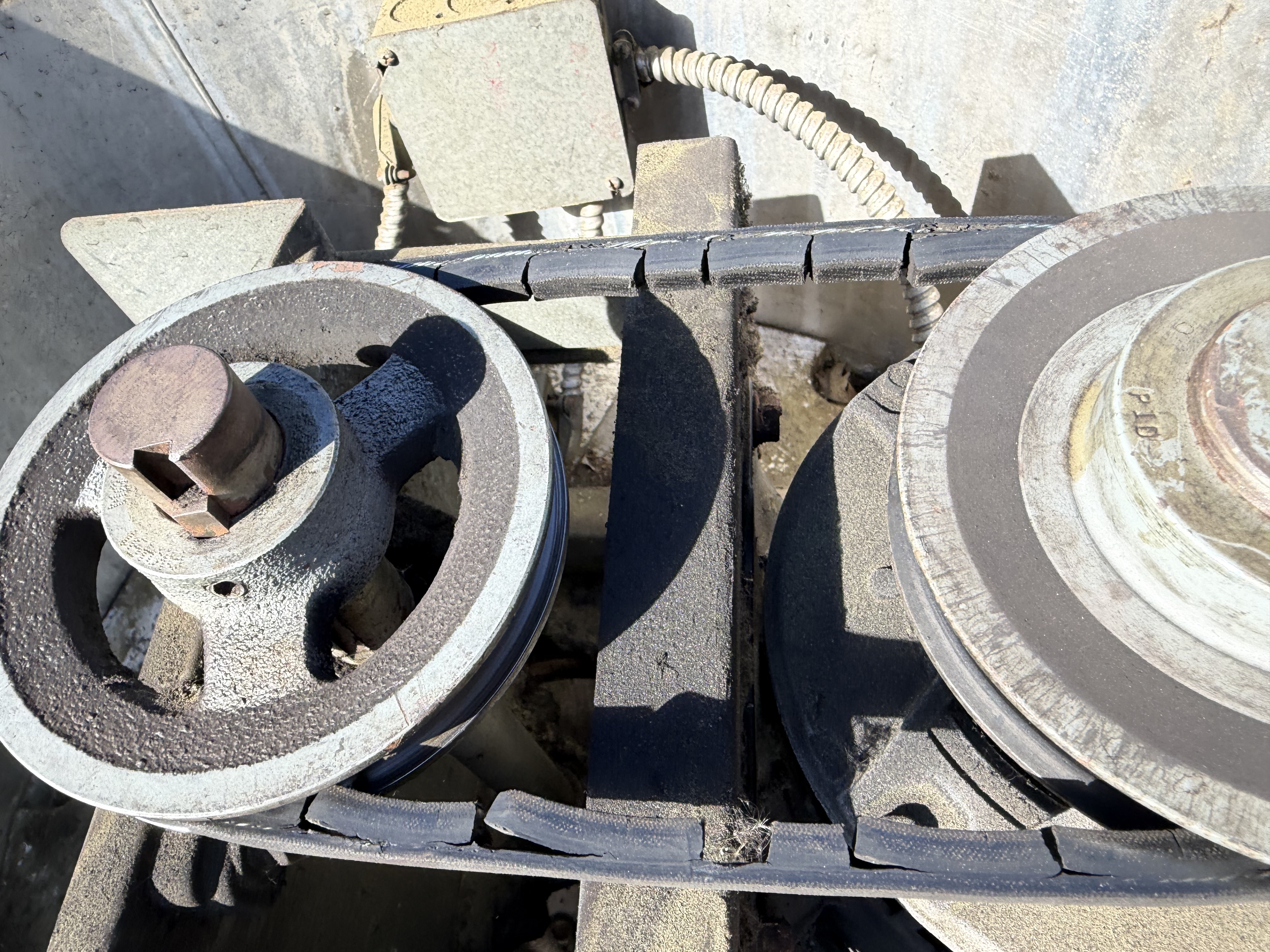 Worn kitchen exhaust fan drive components and pulleys on a commercial rooftop system