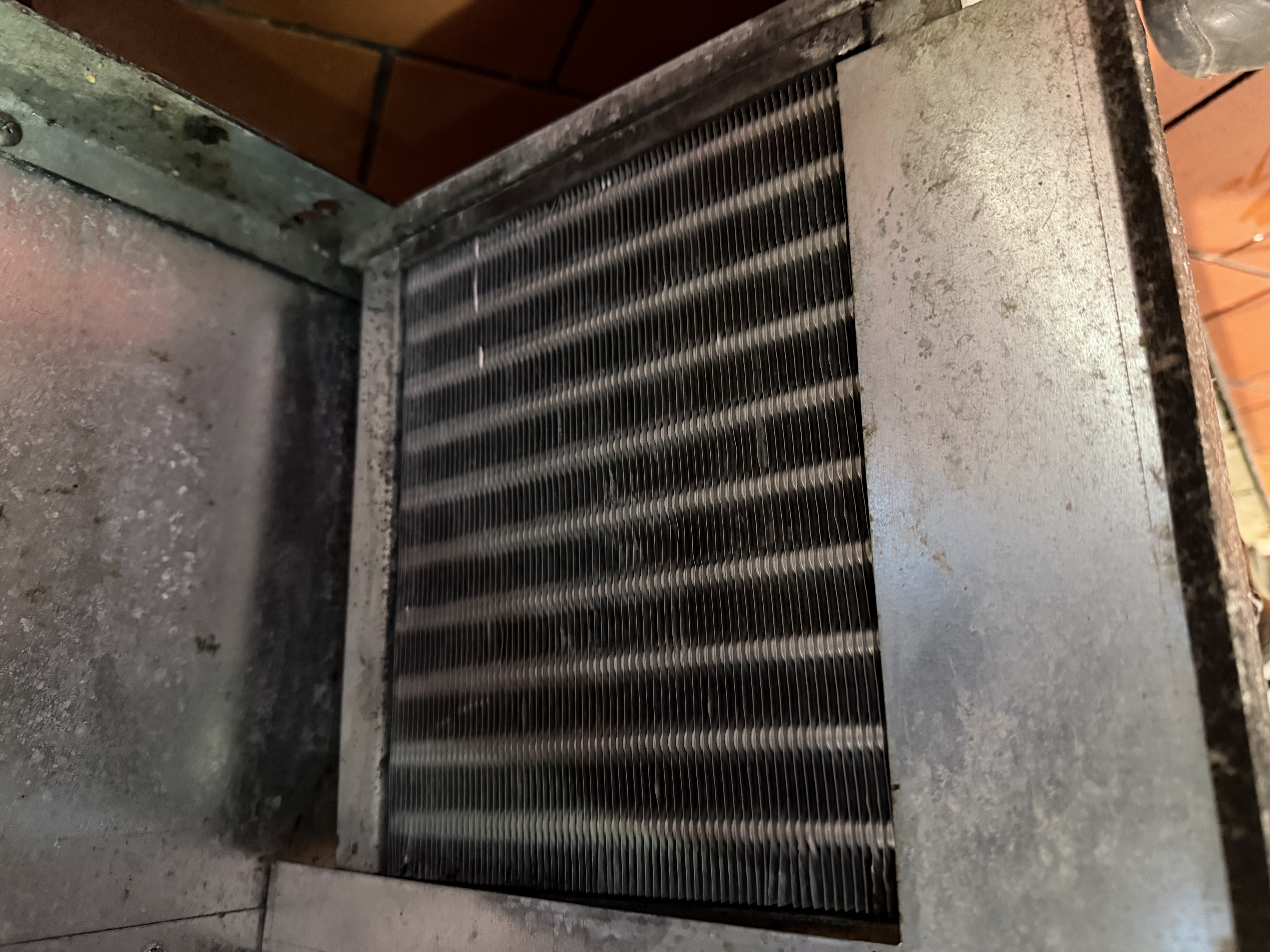 After cleaning on the same reach-in cooler, showing a cleaned coil and filter section during restaurant maintenance